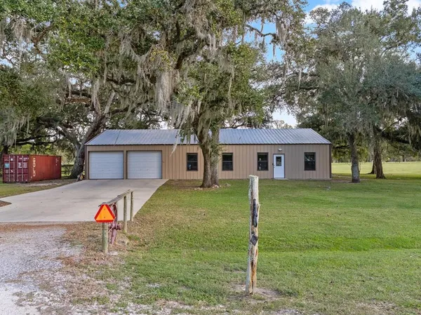 a front view of a house with a yard and trees