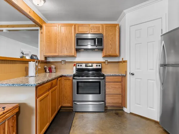 a kitchen with granite countertop a stove and a microwave
