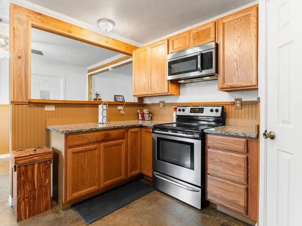a kitchen with stainless steel appliances granite countertop a sink stove and microwave