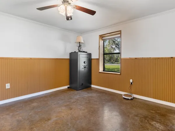 an empty room with closet and a chandelier fan