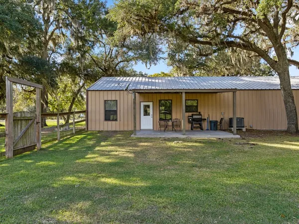 a view of a house with backyard and sitting area