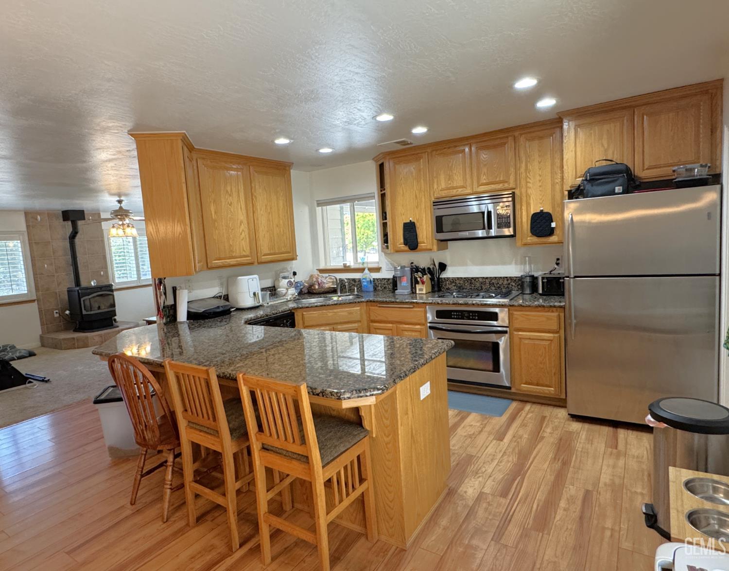 Undisclosed Address Tehachapi, CA 93561 - Photo 1 of 16 a kitchen with granite countertop a stove a sink a refrigerator and a dining table with wooden floor