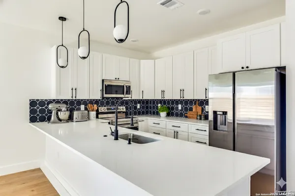 a kitchen with stainless steel appliances granite countertop a sink a stove and refrigerator