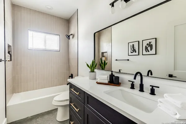 a bathroom with a double vanity sink toilet and shower