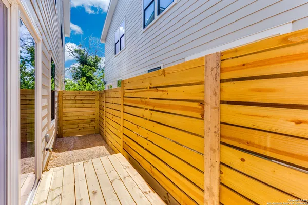 a view of a balcony with wooden floor and fence