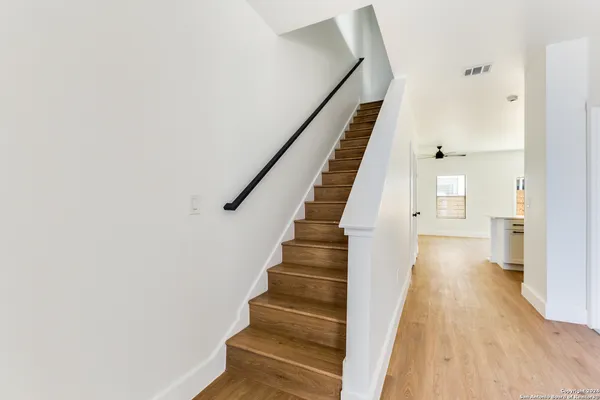 a view of staircase with wooden floor and white walls