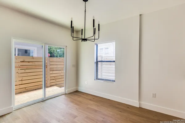 a view of empty room with wooden floor and window