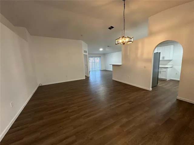 a view of a room with wooden floor and a ceiling fan