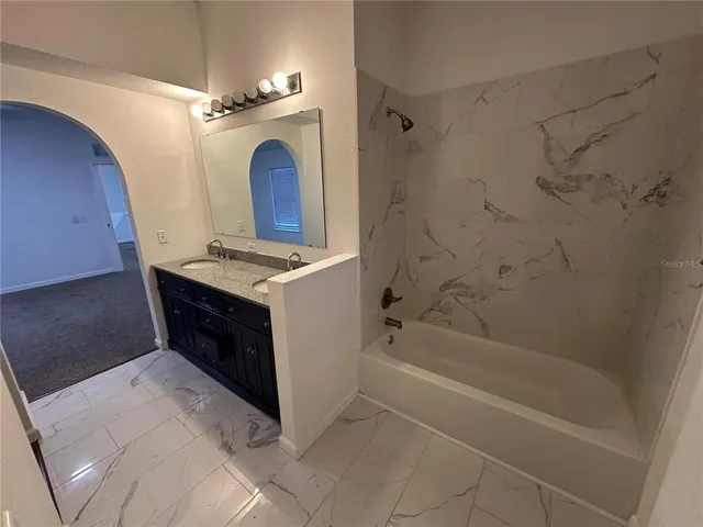 a bathroom with a sink a toilet a mirror and shower