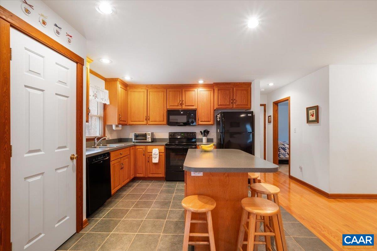 1411 Hill Hollow Road Faber, VA 22938 - Photo 9 of 50 a kitchen with stainless steel appliances granite countertop a sink a stove a refrigerator cabinets and chairs