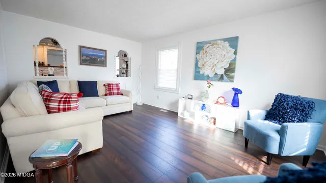 a living room with furniture and a wooden floor