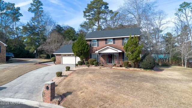 a front view of a house with a yard and tree s