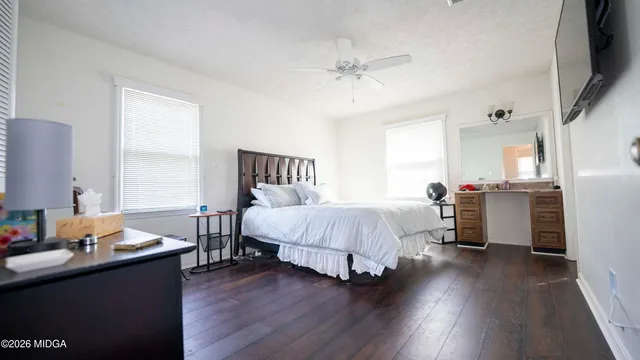 a bedroom with a bed and wooden floor