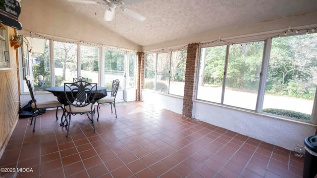 a dining room with furniture and large windows