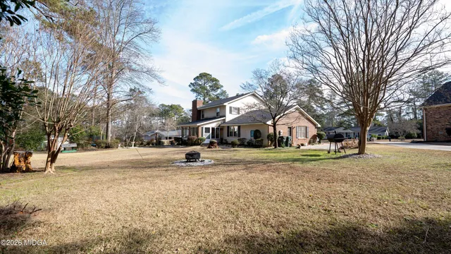 a view of a yard with a house and a large tree