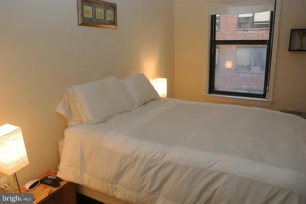 a large bed sitting in a bedroom next to a window