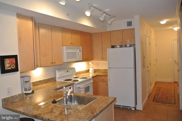 a kitchen with kitchen island a counter top space cabinets and stainless steel appliances