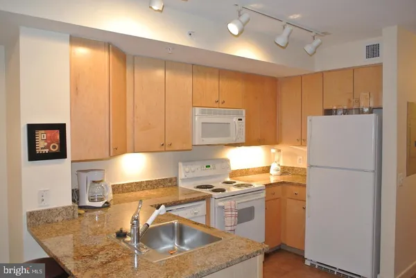 a kitchen with a refrigerator a stove a sink and a counter top space