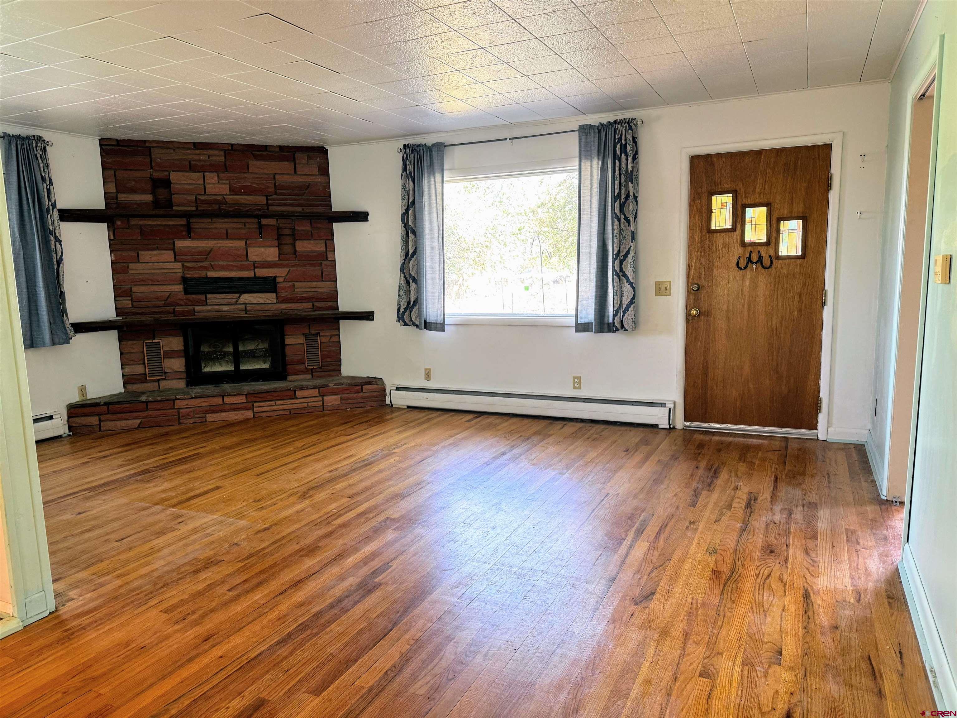 20114 Austin Road Austin, CO 81410 - Photo 5 of 26 an empty room with wooden floor and a window