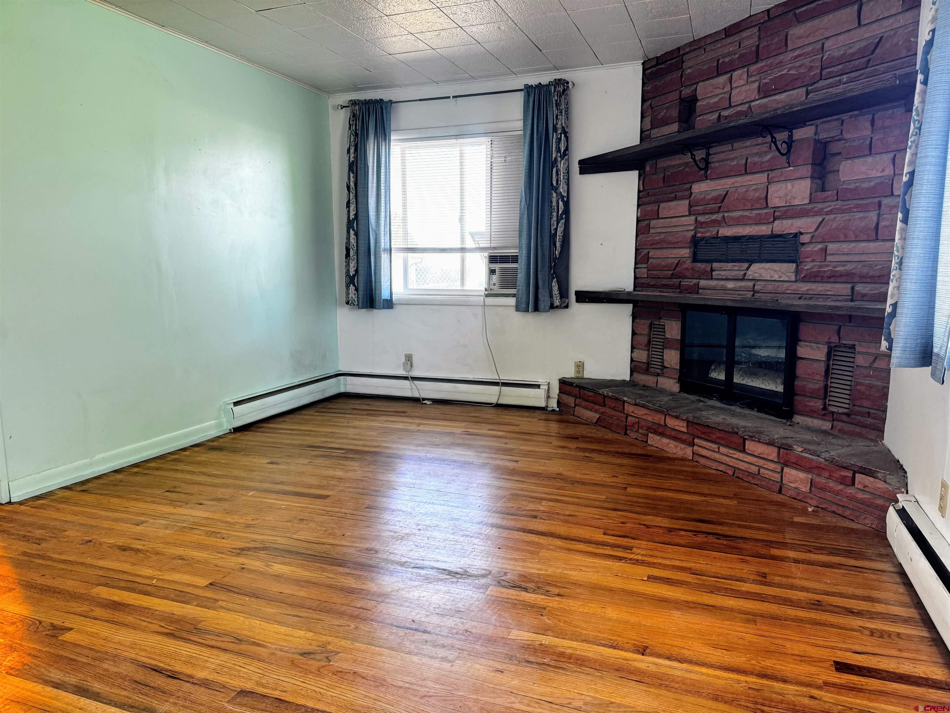 20114 Austin Road Austin, CO 81410 - Photo 6 of 26 a view of empty room with wooden floor and fireplace