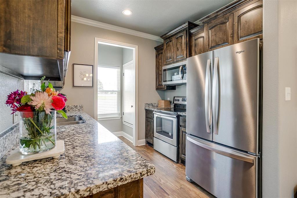 2708 James Road Granbury, TX 76049 - Photo 18 of 34 a kitchen with refrigerator and microwave