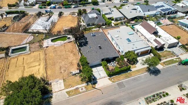 an aerial view of residential houses with yard