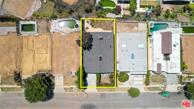 an aerial view of residential houses with outdoor space and parking