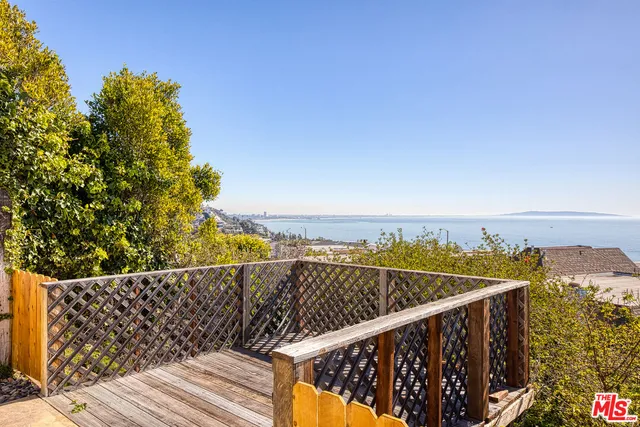 a view of balcony with wooden floor and fence