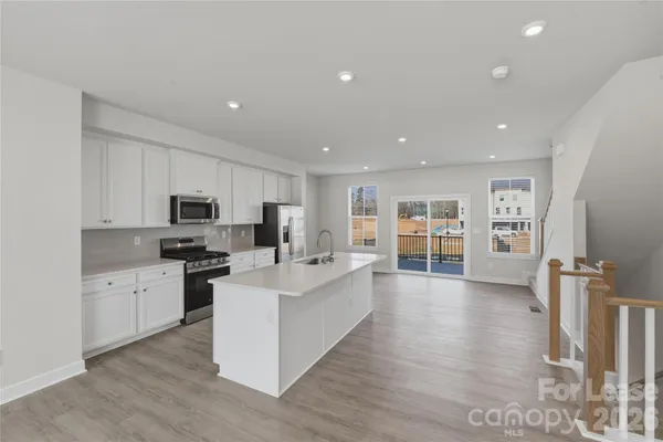a large white kitchen with stainless steel appliances