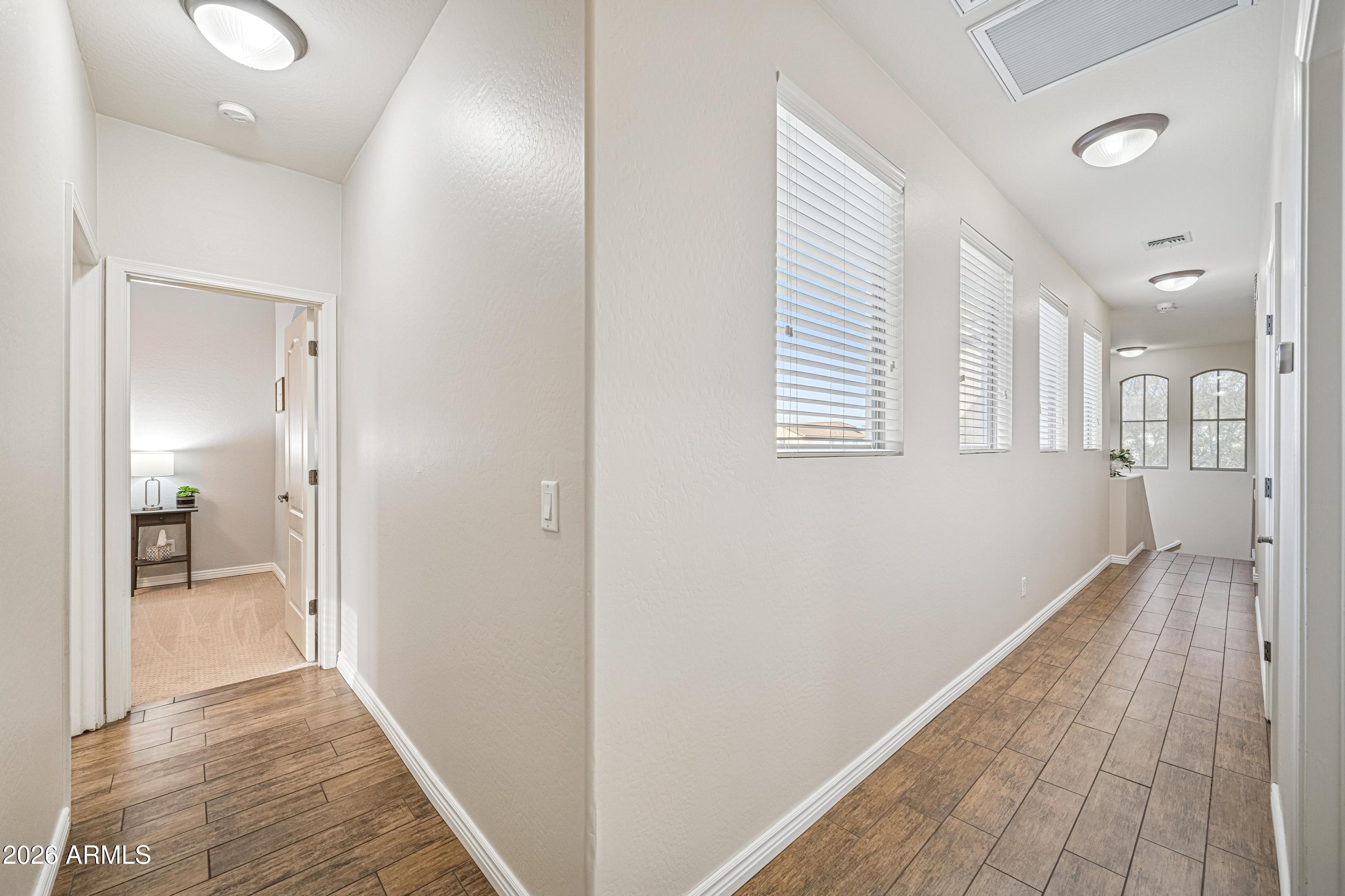 3942 South Mandarin Way Gilbert, AZ 85297 - Photo 18 of 32 a view of hallway with wooden floor and a bathroom