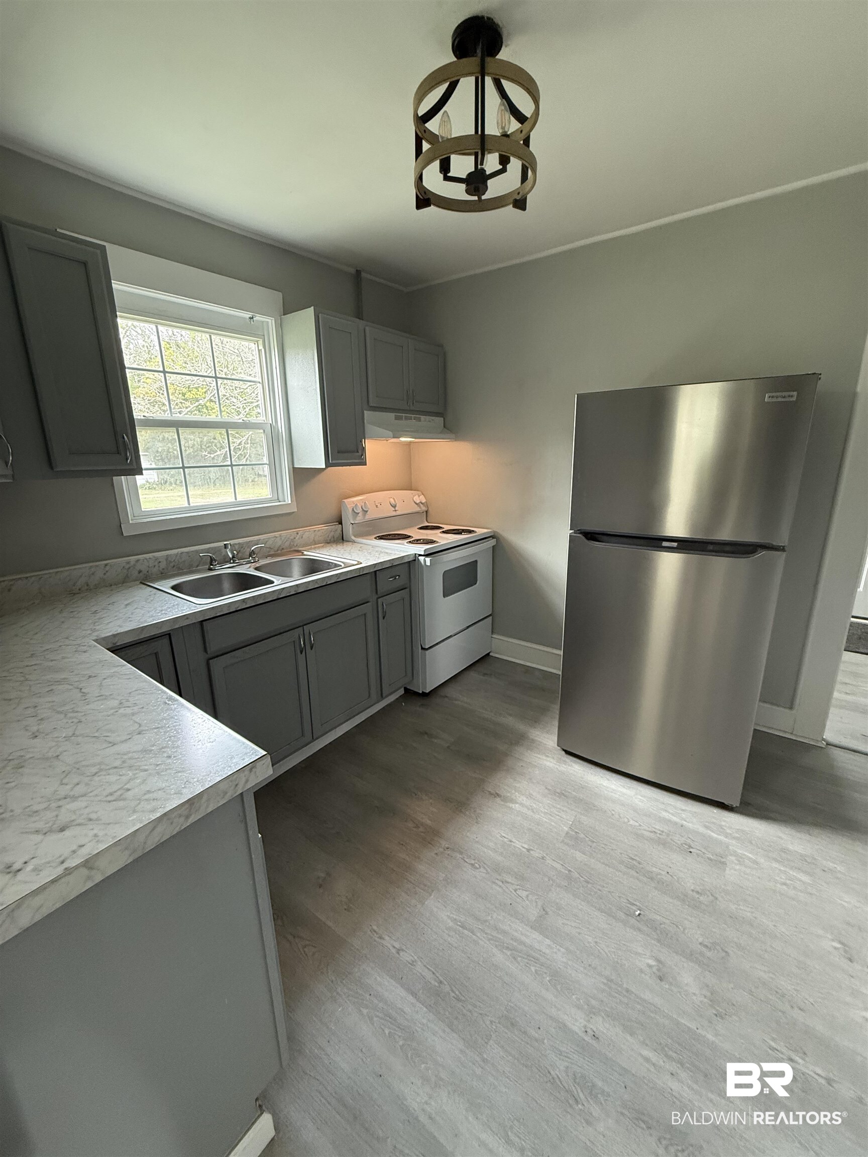 1848 Canal Street Mobile, AL 36606 - Photo 7 of 11 Kitchen featuring gray cabinets, freestanding refrigerator, white range with electric cooktop, light countertops, and light wood-style flooring