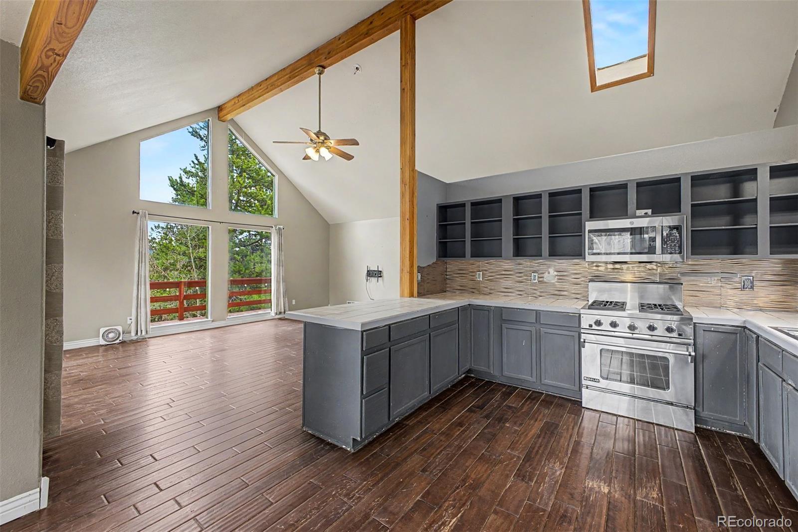 76 Highlands Drive Bailey, CO 80421 - Photo 9 of 49 a kitchen with stainless steel appliances granite countertop a stove and cabinets