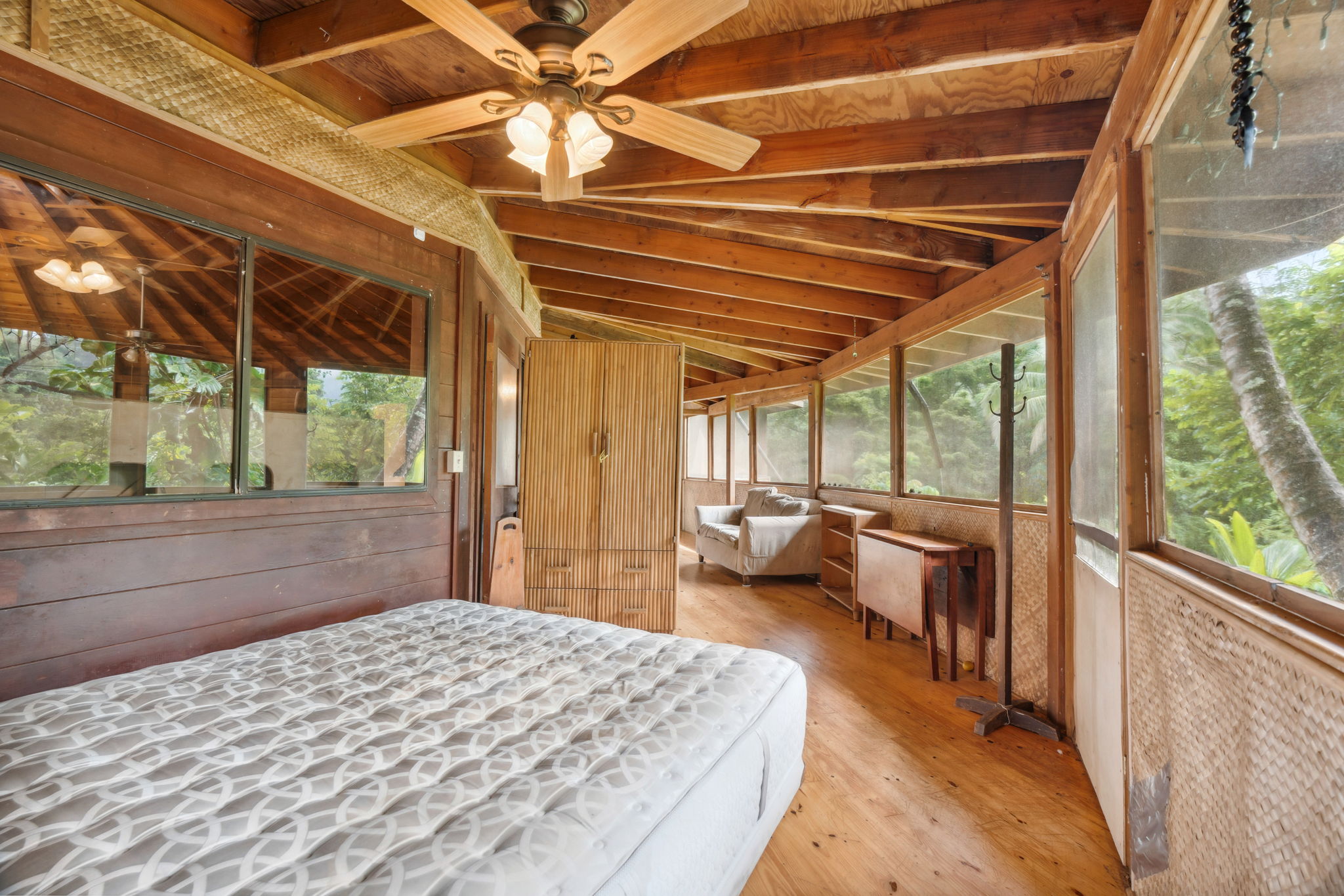 5051 Wainiha Powerhouse Road Hanalei, HI 96714 - Photo 8 of 28 a bedroom with a bed and wooden floor