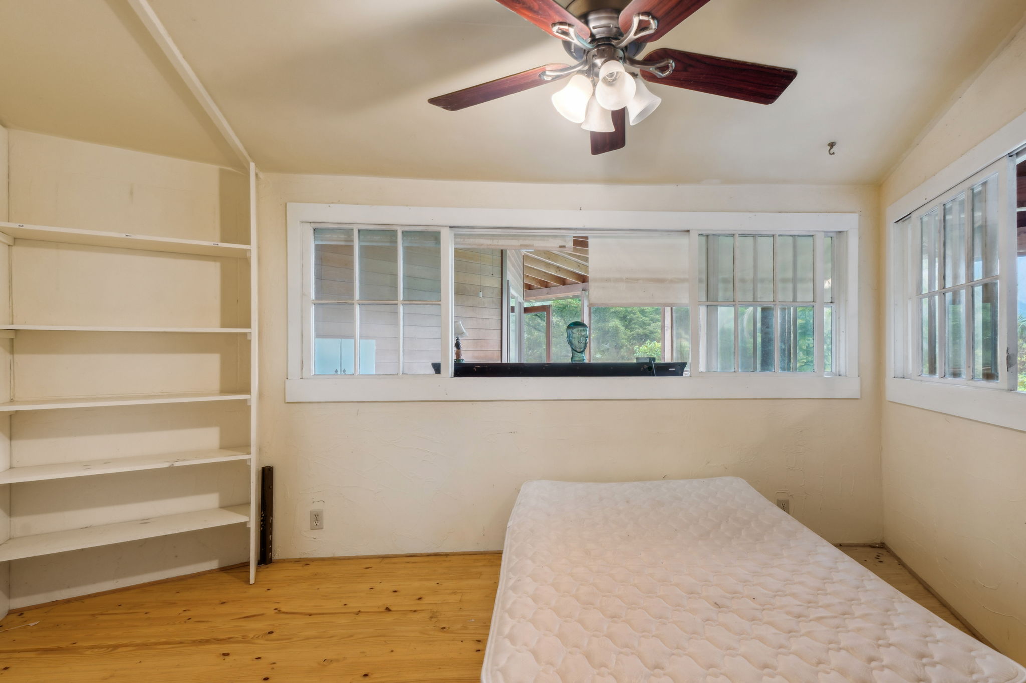 5051 Wainiha Powerhouse Road Hanalei, HI 96714 - Photo 9 of 28 a view of an empty room with a window and wooden floor