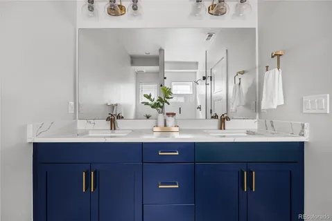 a bathroom with double sink and a mirror