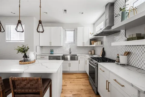 a kitchen with stainless steel appliances a sink a stove and cabinets