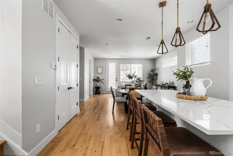 a view of a dining room and livingroom with furniture wooden floor a chandelier