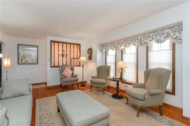 VIEW FROM FAR SIDE OF LIVING ROOM SHOWING ENTRY.  WINDOW TREATMENTS STAY THROUGHOUT HOME!