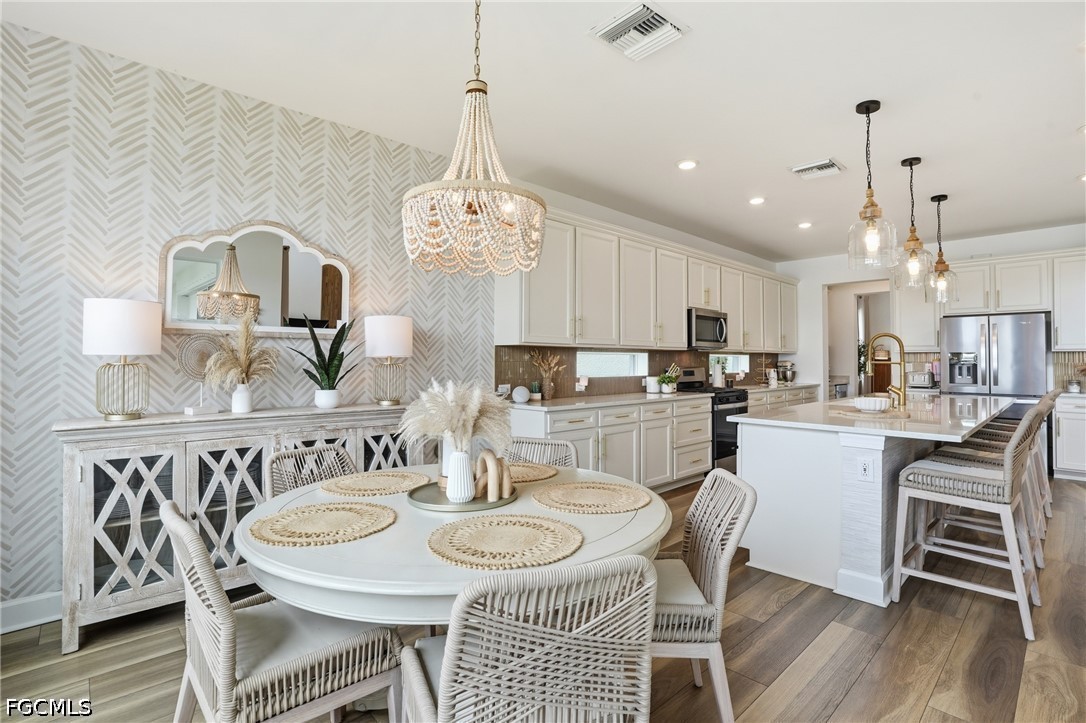 15572 Northridge Road Punta Gorda, FL 33982 - Photo 16 of 48 a kitchen with stainless steel appliances kitchen island granite countertop a dining table chairs and a refrigerator