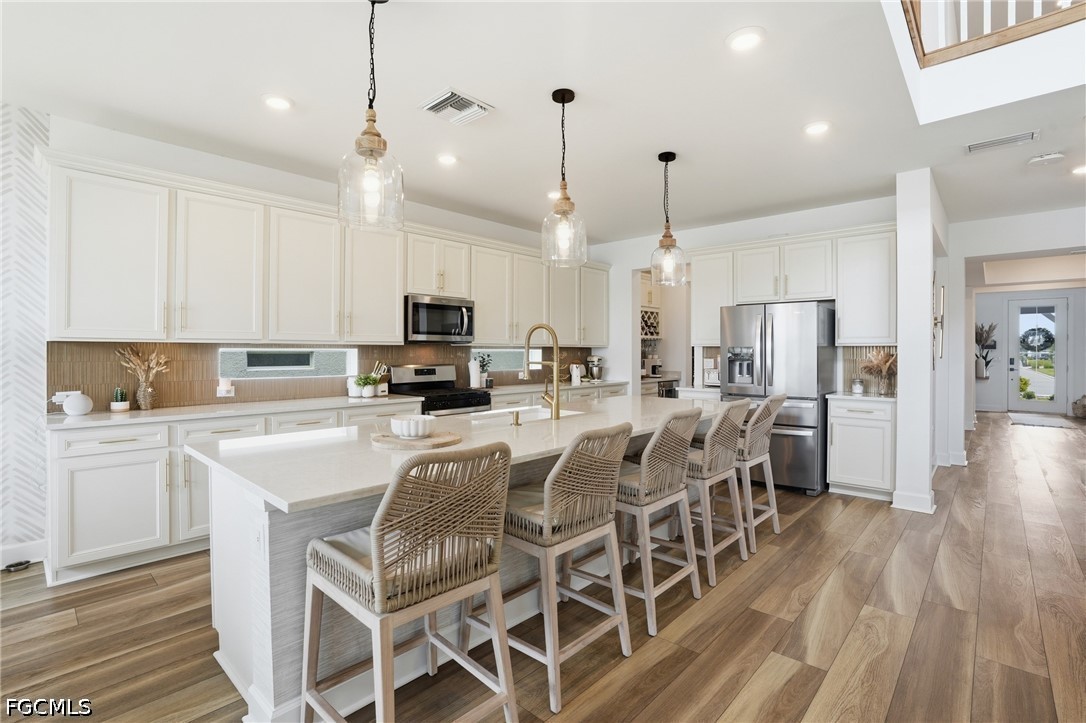 15572 Northridge Road Punta Gorda, FL 33982 - Photo 10 of 48 a kitchen with stainless steel appliances kitchen island granite countertop a refrigerator a stove top oven a sink dishwasher and white cabinets with wooden floor