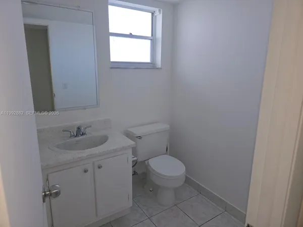 a bathroom with a granite countertop toilet a sink and a bathtub