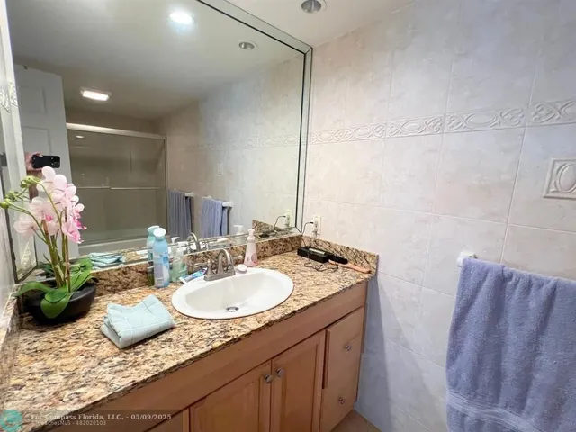 a bathroom with a granite countertop sink a toilet and a mirror