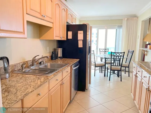 a kitchen with stainless steel appliances granite countertop a sink and a dining table