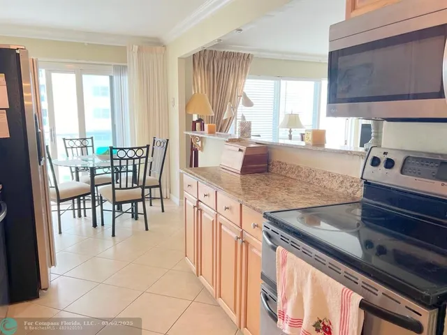 a open kitchen with granite countertop a sink and a large window