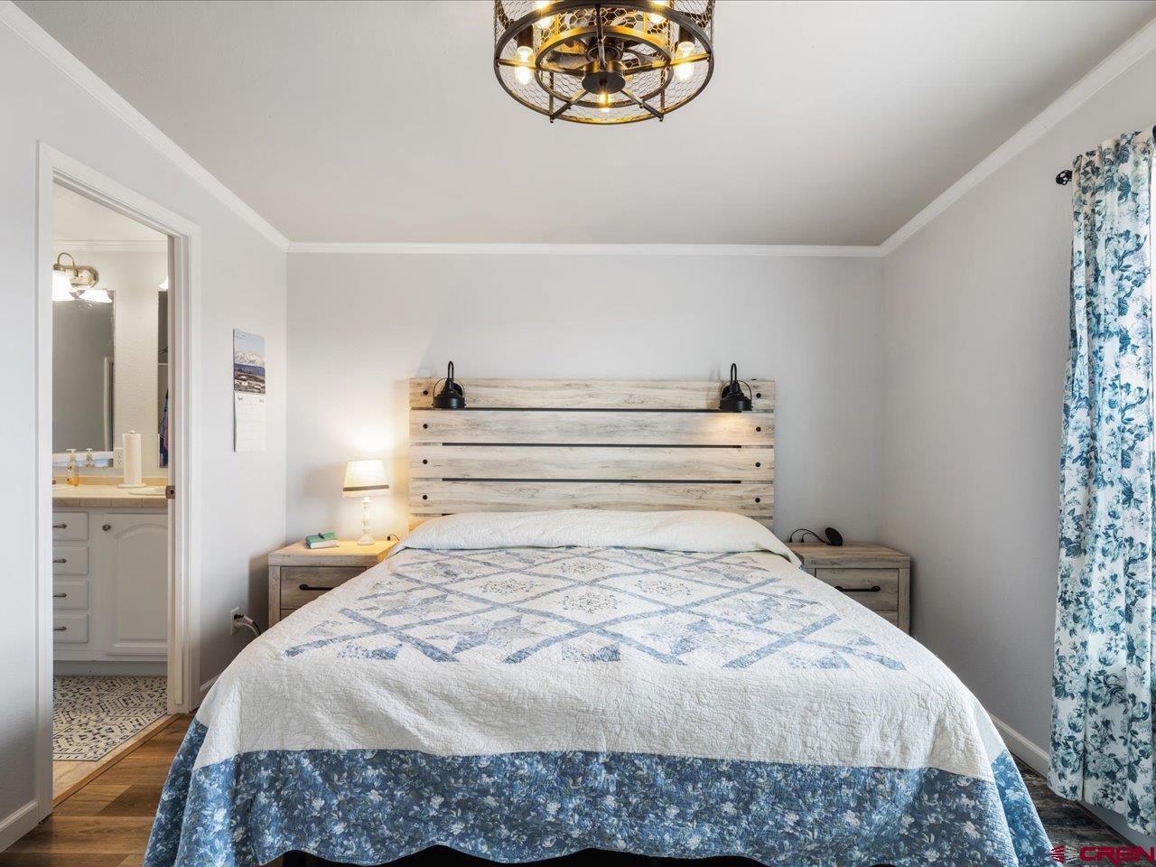1857 Sego Lane Delta, CO 81416 - Photo 18 of 34 a bedroom with a bed and a chandelier