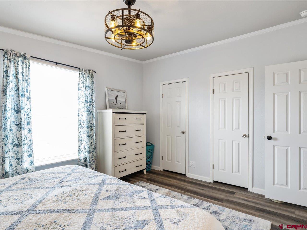 1857 Sego Lane Delta, CO 81416 - Photo 19 of 34 a bedroom with a bed and a chandelier