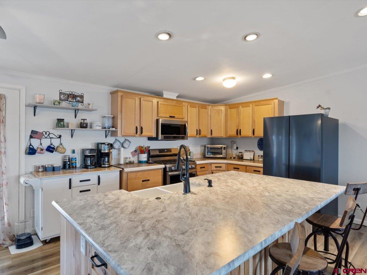 1857 Sego Lane Delta, CO 81416 - Photo 10 of 34 a kitchen with stainless steel appliances a stove a sink a microwave a refrigerator and cabinets