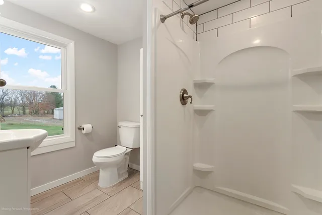 a bathroom with a granite countertop toilet a sink and a shower
