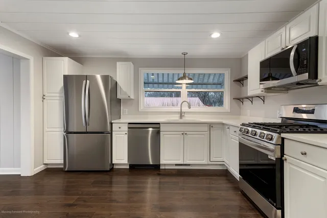 a kitchen with stainless steel appliances a refrigerator stove and microwave