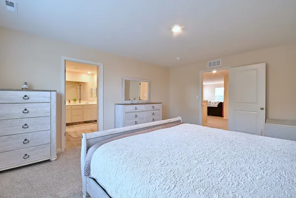 a bedroom with a large bed and dresser